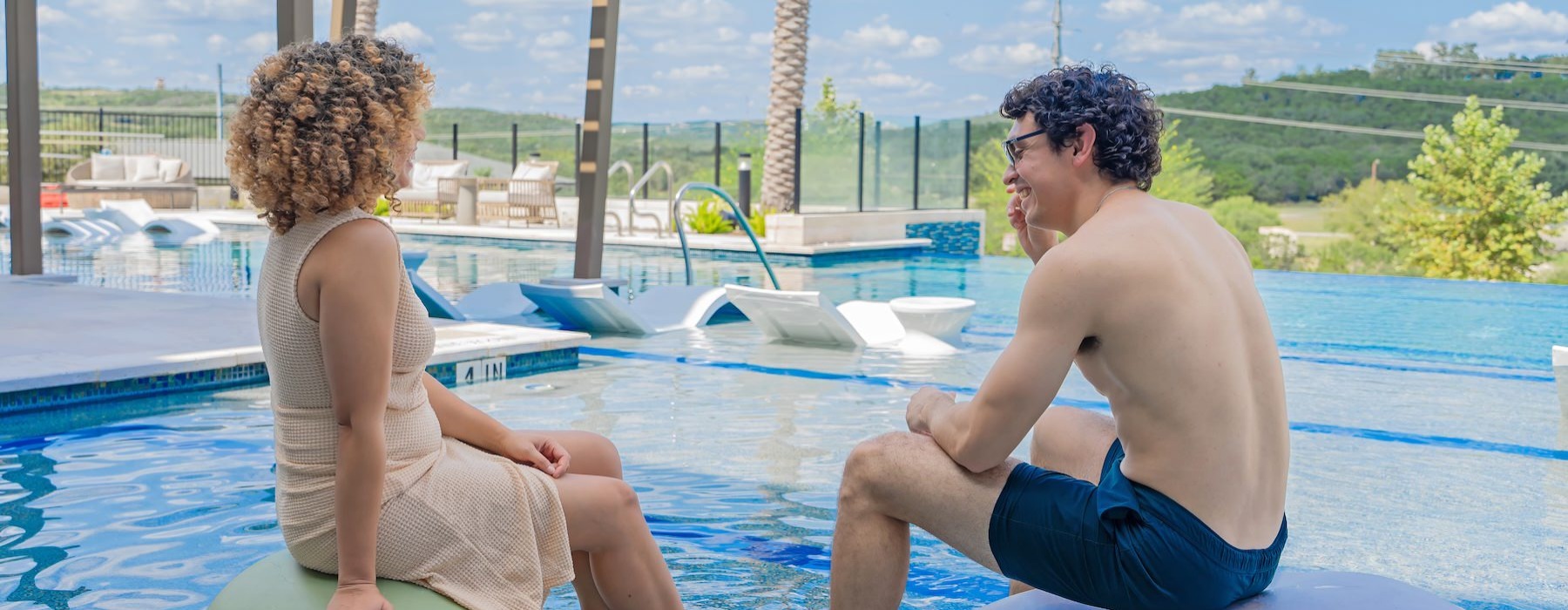 two people sitting in a pool talking